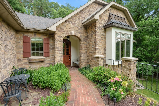 1431 Edgemoor Ave, Kalamazoo, MI 49008 - doorway to property with stone siding, a shingled roof, and stucco siding