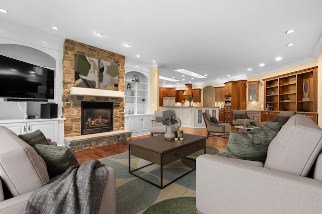 1431 Edgemoor Ave, Kalamazoo, MI 49008 - living room with wood finished floors, crown molding, a stone fireplace, recessed lighting, and built in shelves