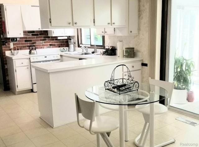 5396 Provincial Dr, Bloomfield Hills, MI 48302 - kitchen with white range with electric stovetop, light countertops, a peninsula, and white cabinetry