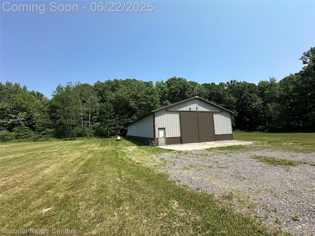 8049 Mckinley Rd, Clay, MI 48001 - view of grassy yard featuring a view of trees, an outbuilding, and a detached garage
