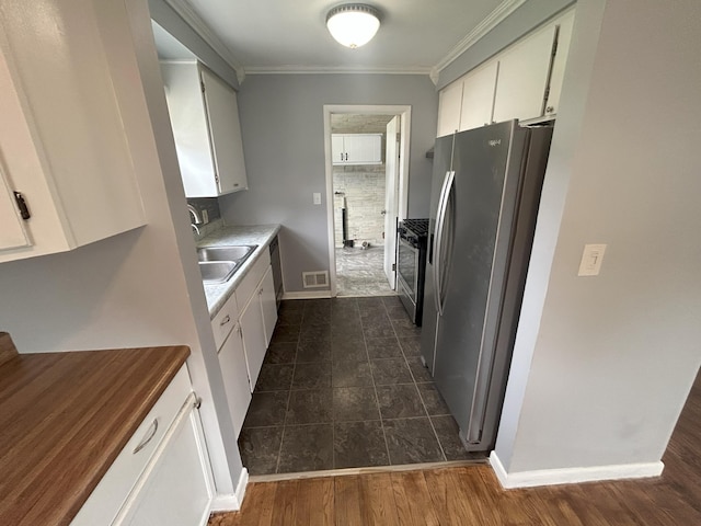 9262 Washington St, Romulus, MI 48174 - kitchen featuring appliances with stainless steel finishes, ornamental molding, white cabinets, light countertops, and dark tile patterned flooring