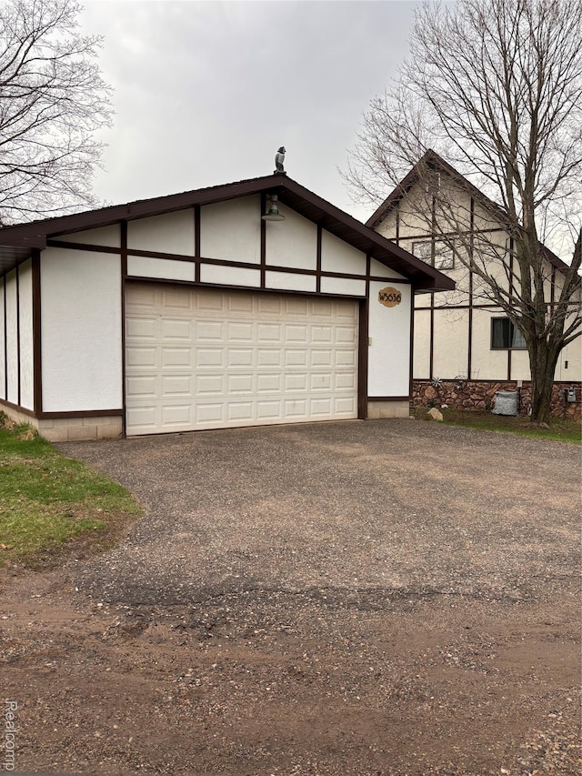 5636 Crescent St, Norway, MI 49870 - view of front of property featuring asphalt driveway, a garage, and stucco siding