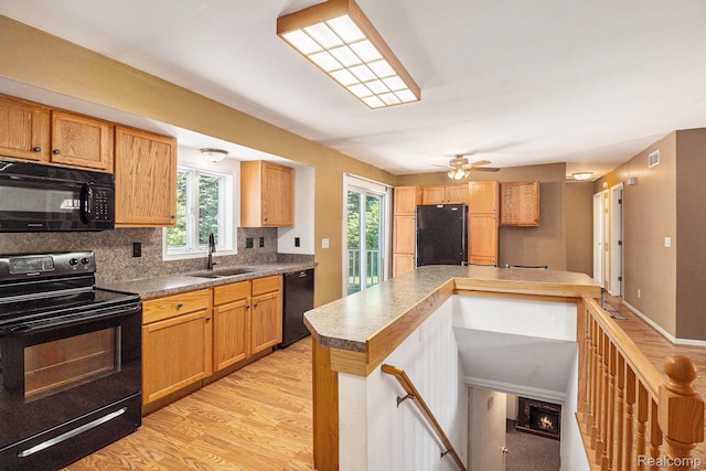 4788 Apache Trl, Columbiaville, MI 48421 - kitchen featuring black appliances, light wood-type flooring, backsplash, and healthy amount of natural light