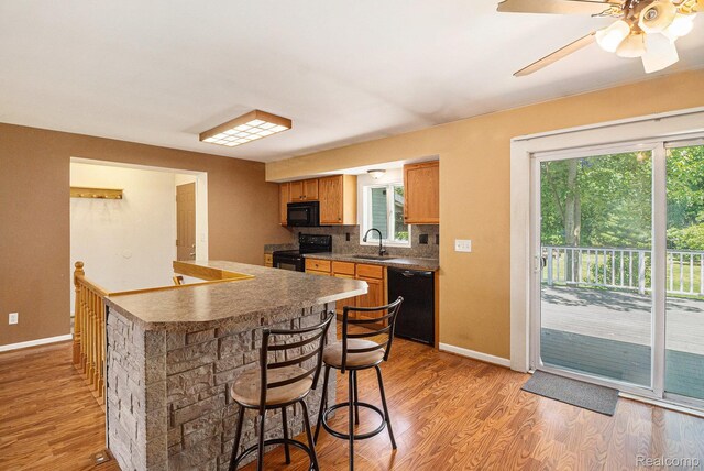 4788 Apache Trl, Columbiaville, MI 48421 - kitchen featuring black appliances, healthy amount of natural light, and light wood-style flooring