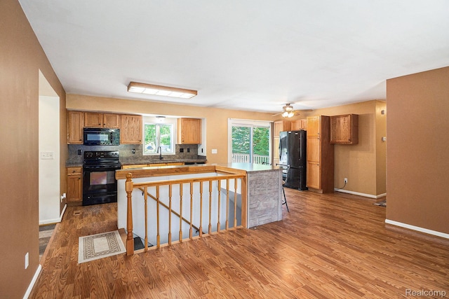 4788 Apache Trl, Columbiaville, MI 48421 - kitchen with black appliances, dark wood-type flooring, a kitchen island, and tasteful backsplash