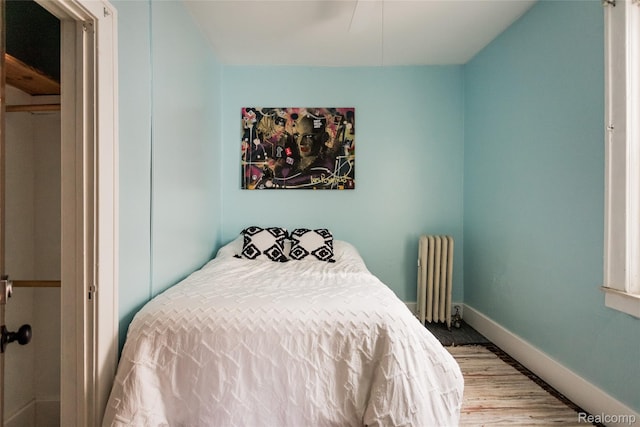 7824 Mount Elliott St, Detroit, MI 48211 - bedroom with radiator heating unit and wood finished floors