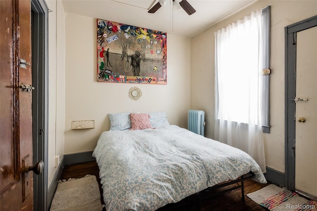 7824 Mount Elliott St, Detroit, MI 48211 - bedroom with multiple windows, radiator heating unit, and dark wood-type flooring