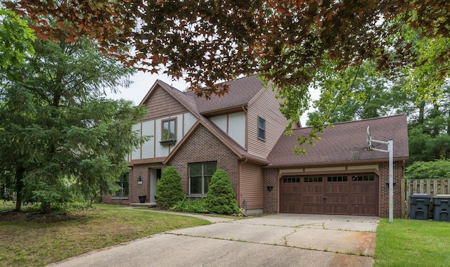6615 Pleasantview Dr, Portage, MI 49024 - tudor house featuring a garage, driveway, brick siding, and roof with shingles