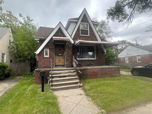 18602 Brinker St, Detroit, MI 48234 - tudor-style house featuring brick siding and a porch