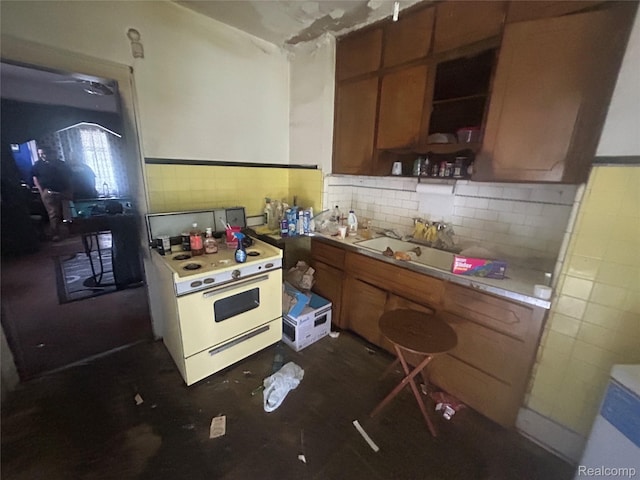 18602 Brinker St, Detroit, MI 48234 - kitchen featuring white electric stove, tile walls, brown cabinets, light countertops, and open shelves
