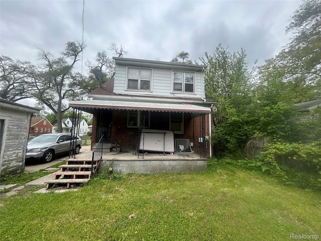 18602 Brinker St, Detroit, MI 48234 - view of front of house with covered porch, a front lawn, and brick siding
