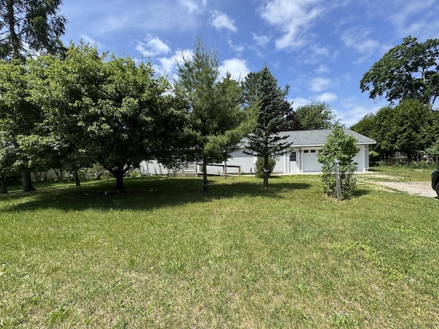 8484 Zosel St, Onekama, MI 49675 - view of grassy yard with a garage and driveway