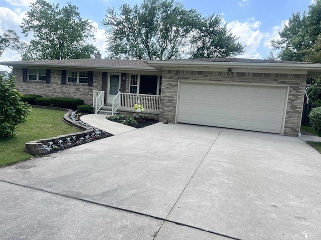 928 S Raisinville Rd, Monroe, MI 48161 - ranch-style house with concrete driveway, brick siding, a garage, a front lawn, and a porch