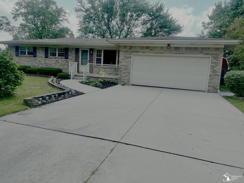 928 S Raisinville Rd, Monroe, MI 48161 - ranch-style home featuring brick siding, concrete driveway, a garage, and a chimney