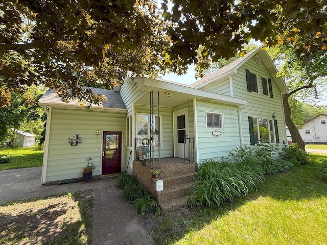 715 Filer Ave, Filer City, MI 49634 - view of front facade featuring a shingled roof and a front yard