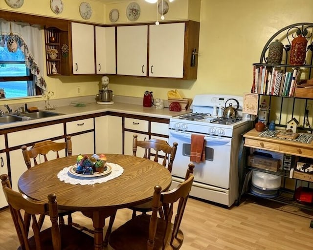 715 Filer Ave, Filer City, MI 49634 - kitchen with gas range gas stove, white cabinets, light countertops, and light wood-type flooring
