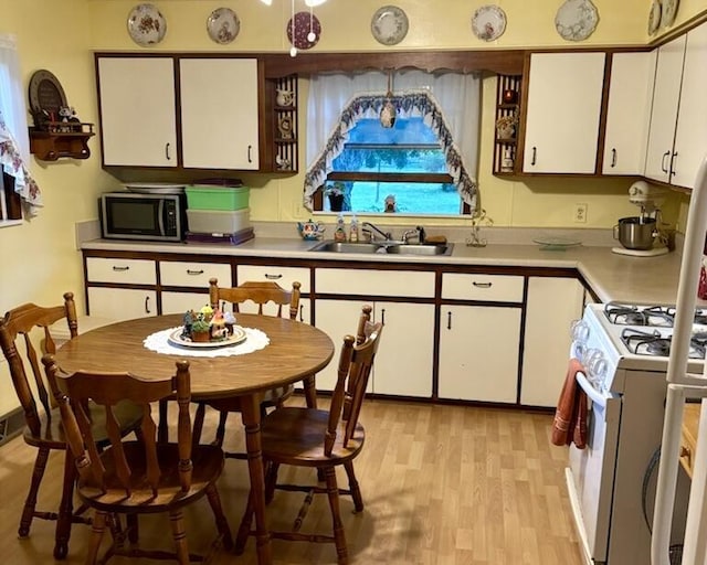 715 Filer Ave, Filer City, MI 49634 - kitchen with stainless steel microwave, white cabinets, light countertops, and light wood-type flooring