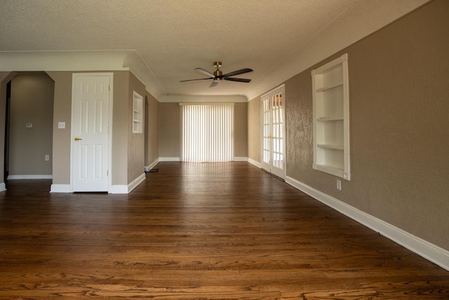 2712 Voorheis Rd, Waterford, MI 48328 - spare room featuring a ceiling fan, a textured ceiling, built in shelves, dark wood-type flooring, and arched walkways