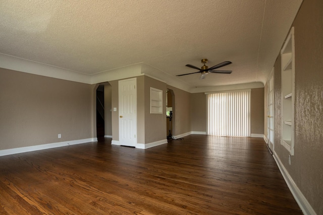 2712 Voorheis Rd, Waterford, MI 48328 - empty room featuring arched walkways, a textured ceiling, dark wood-type flooring, and ceiling fan