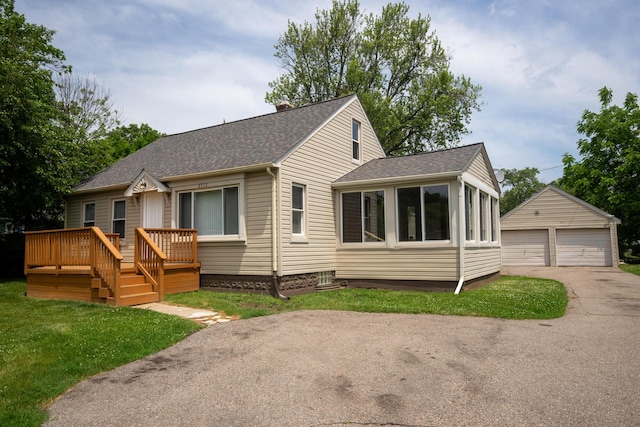 2712 Voorheis Rd, Waterford, MI 48328 - view of front of home with a detached garage, an outbuilding, a shingled roof, a wooden deck, and a front yard