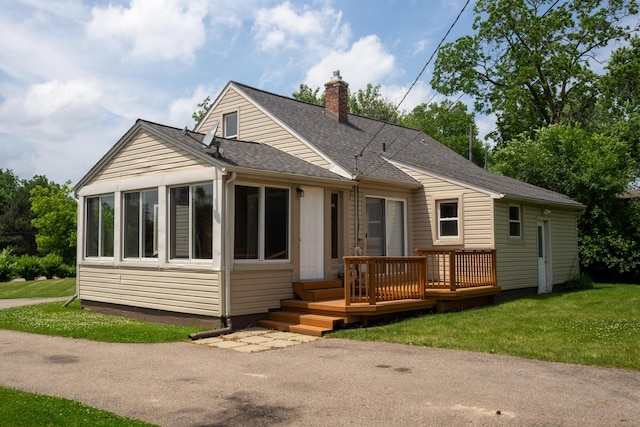 2712 Voorheis Rd, Waterford, MI 48328 - view of front of property featuring a chimney, a wooden deck, a front yard, a shingled roof, and a sunroom