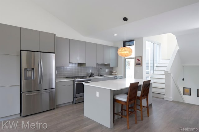 2821 Brush St, Detroit, MI 48201 - kitchen featuring stainless steel appliances, gray cabinetry, wood finished floors, backsplash, and light countertops