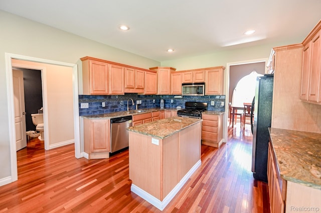 7396 Elms Rd, Swartz Creek, MI 48473 - kitchen with appliances with stainless steel finishes, light brown cabinetry, light wood-style floors, backsplash, and recessed lighting