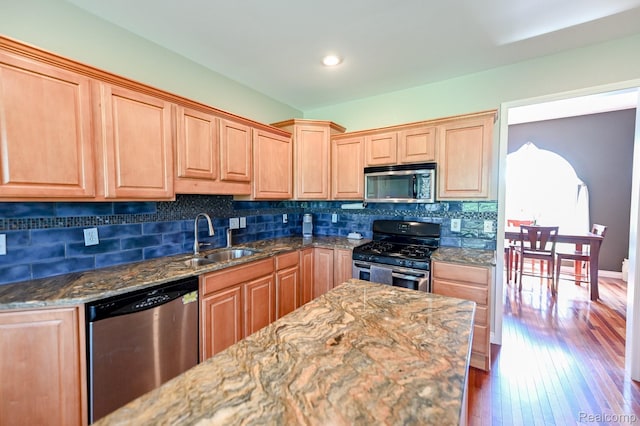7396 Elms Rd, Swartz Creek, MI 48473 - kitchen featuring appliances with stainless steel finishes, wood-type flooring, dark stone countertops, backsplash, and light brown cabinets