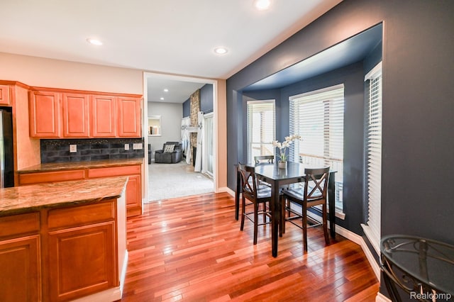7396 Elms Rd, Swartz Creek, MI 48473 - dining space with light wood-style flooring, recessed lighting, and a fireplace