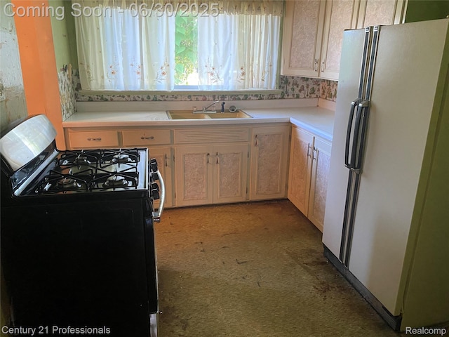 972 Tacken St, Flint, MI 48532 - kitchen with freestanding refrigerator, range with gas cooktop, light countertops, and light colored carpet