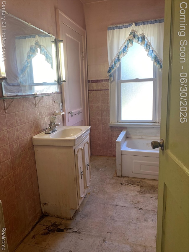 972 Tacken St, Flint, MI 48532 - full bathroom featuring a garden tub, vanity, tile walls, and a wainscoted wall