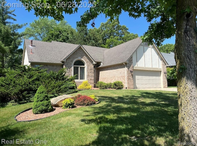 2184 Reagan Dr, Rochester Hills, MI 48309 - view of front facade featuring an attached garage, a front yard, brick siding, and a shingled roof