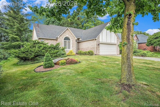 2184 Reagan Dr, Rochester Hills, MI 48309 - view of front of house featuring a garage, brick siding, and a front yard