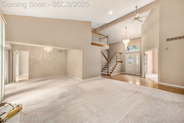 2184 Reagan Dr, Rochester Hills, MI 48309 - carpeted entrance foyer featuring high vaulted ceiling, a chandelier, stairway, and a ceiling fan