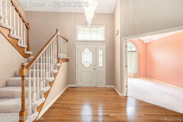 2184 Reagan Dr, Rochester Hills, MI 48309 - foyer with stairs, a towering ceiling, wood finished floors, and a chandelier