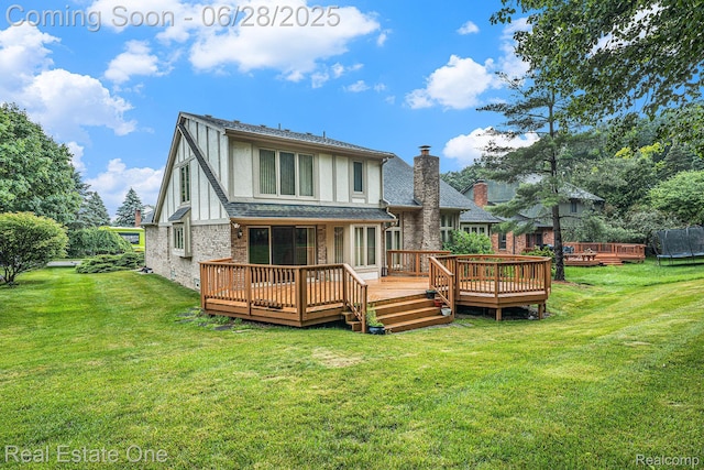 2184 Reagan Dr, Rochester Hills, MI 48309 - rear view of house featuring a wooden deck, a yard, brick siding, and stucco siding
