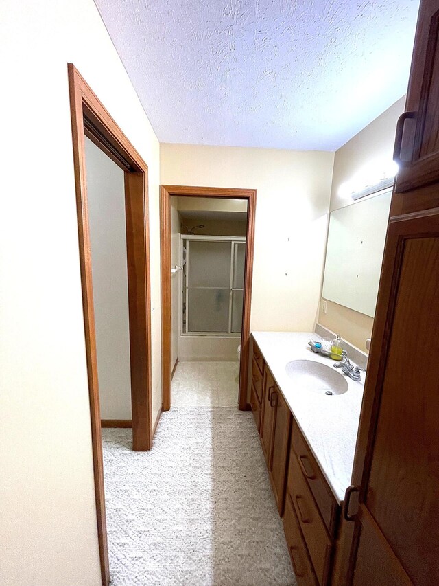 5753 Wood Valley Rd, Kalamazoo, MI 49009 - full bath with vanity, a textured ceiling, and bath / shower combo with glass door