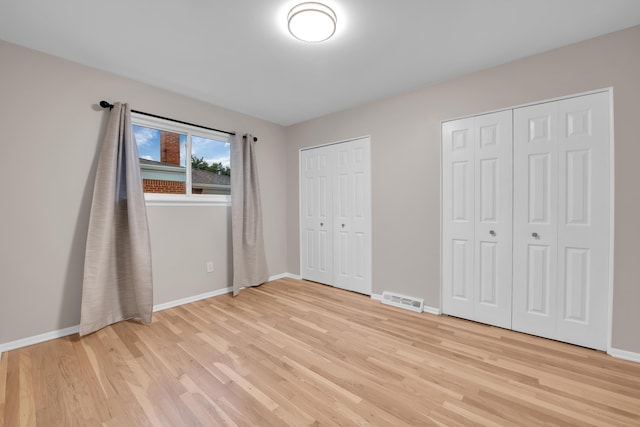27152 Broadmoor Dr, Warren, MI 48088 - unfurnished bedroom featuring light wood finished floors and multiple closets