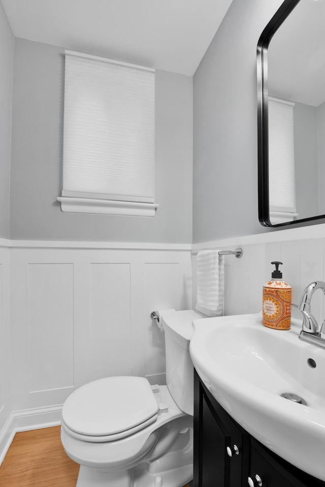 27152 Broadmoor Dr, Warren, MI 48088 - half bathroom featuring vanity, a decorative wall, wainscoting, and wood finished floors
