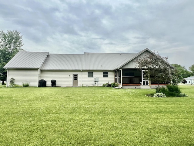 755 Tomahawk Trl, Coldwater, MI 49036 - back of property featuring a sunroom, a metal roof, and a lawn