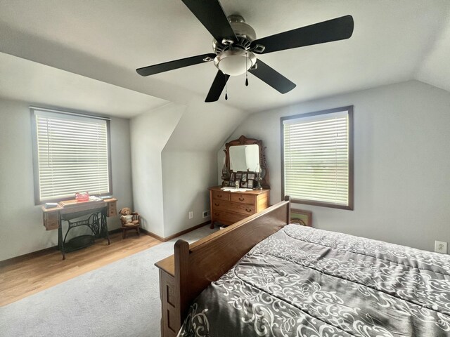 755 Tomahawk Trl, Coldwater, MI 49036 - carpeted bedroom with vaulted ceiling, multiple windows, a ceiling fan, and wood finished floors