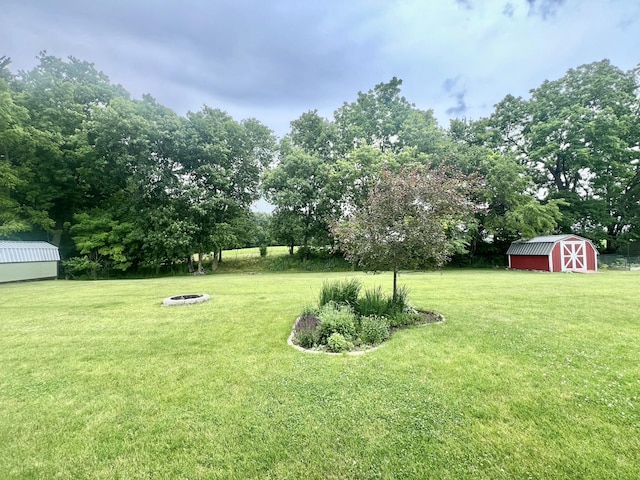 755 Tomahawk Trl, Coldwater, MI 49036 - view of green lawn featuring a storage shed, a fire pit, and view of wooded area