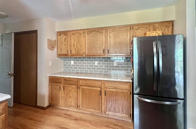 755 Tomahawk Trl, Coldwater, MI 49036 - kitchen featuring freestanding refrigerator, light countertops, light wood-type flooring, and backsplash
