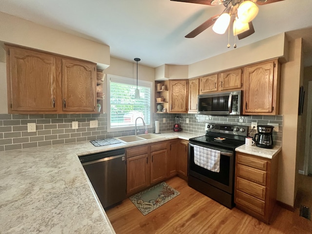 755 Tomahawk Trl, Coldwater, MI 49036 - kitchen with stainless steel appliances, open shelves, light wood-style flooring, light countertops, and backsplash
