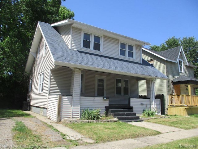 1027 Elmwood St, Port Huron, MI 48060 - bungalow with a porch, a shingled roof, and a front lawn
