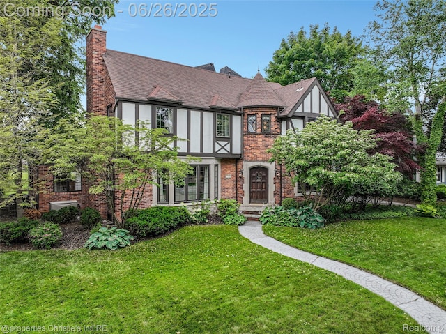 753 Grand Marais St, Grosse Pointe Park, MI 48230 - tudor-style house with brick siding, a front lawn, a chimney, and roof with shingles