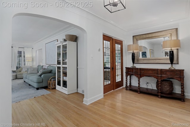 753 Grand Marais St, Grosse Pointe Park, MI 48230 - foyer entrance featuring french doors, arched walkways, crown molding, wood-type flooring, and healthy amount of natural light