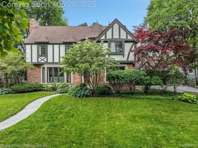 753 Grand Marais St, Grosse Pointe Park, MI 48230 - tudor house with brick siding, a front lawn, a chimney, and stucco siding