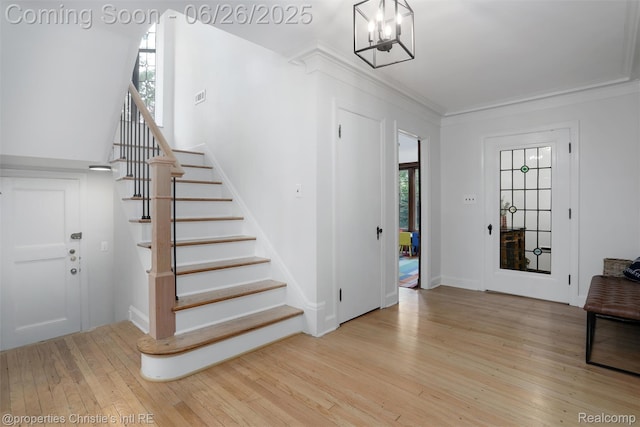 753 Grand Marais St, Grosse Pointe Park, MI 48230 - foyer with wood-type flooring, stairs, a chandelier, and ornamental molding