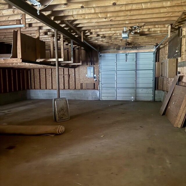 218 W Stover Rd, Standish, MI 48658 - garage with electric panel, a garage door opener, and concrete block wall